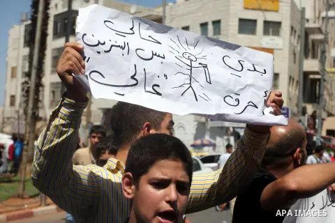 Palestinians hold placards against prime minister Salam Fayyad during a protest against the hight cost of living in the West Bank city of Ramallah on September 5, 2012. Photo by Issam Rimawi