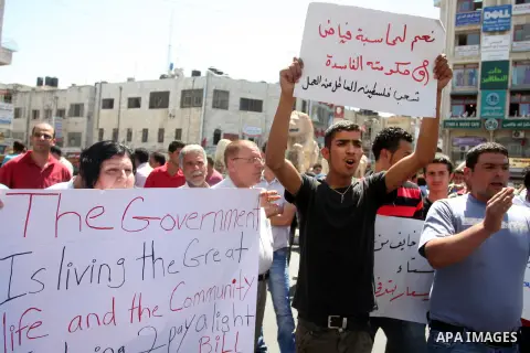 Palestinians hold placards against prime minister Salam Fayyad during a protest against the hight cost of living in the West Bank city of Ramallah on September 5, 2012. Photo by Issam Rimawi