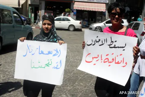 Palestinians hold placards against prime minister Salam Fayyad during a protest against the hight cost of living in the West Bank city of Ramallah on September 5, 2012. Photo by Issam Rimawi