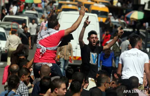 Palestinians hold placards against prime minister Salam Fayyad during a protest against the hight cost of living in the West Bank city of Ramallah on September 5, 2012. Photo by Issam Rimawi