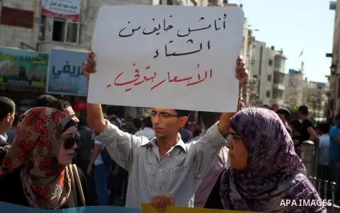 Palestinians hold placards against prime minister Salam Fayyad during a protest against the hight cost of living in the West Bank city of Ramallah on September 5, 2012. Photo by Issam Rimawi