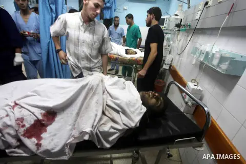 Palestinians stand by the body of one of three Palestinian militants killed in an Israeli airstrike earlier on September 5, 2012, at the morgue of the al-Aqsa hospital in Deir al-Balah, Gaza strip center. Photo by Ashraf...