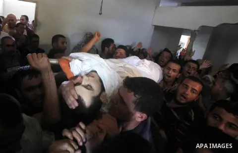 Palestinian mourners carry the body of Tareq al-Kafarna mourn during his funeral in Beit Hanun in the northern Gaza Strip on September 6, 2012. Three Palestinians were killed by Israeli fire in the northern Gaza Strip, r...
