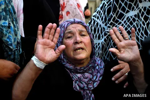 A relative of Ihab and Akram al-Zaanin, two Palestinian brothers who were killed by Israeli fire, is comforted by family members as she mourns during their funeral in Beit Hanun in the northern Gaza Strip on September 6,...