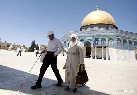 Palestinians walk in front of the Dome of Rock mosque during Friday prayers, in the Al Aqsa Mosque compound, in Jerusalem's old city on Sep. 07, 2012. Photo by Mahfouz Abu Turk