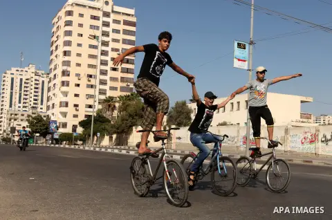 Palestinian youth ride a bicycle on a street in Gaza City, on Sep. 07, 2012. Photo by Majdi Fathi