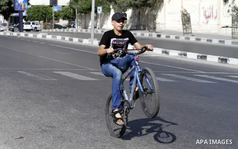Palestinian youth ride a bicycle on a street in Gaza City, on Sep. 07, 2012. Photo by Majdi Fathi