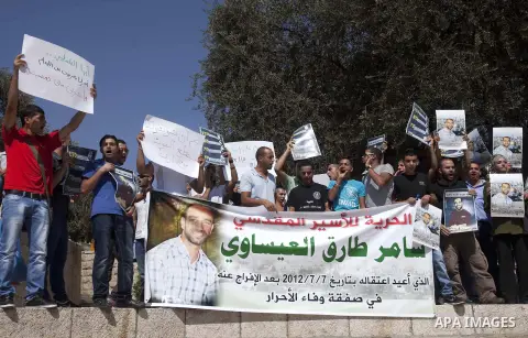 An Israeli soldier films Palestinian protesters as they shout slogans and hold portraits of prisoners in Israeli jails during a demonstration in solidarity with jailed Palestinians outside Damascus Gate in the old city o...