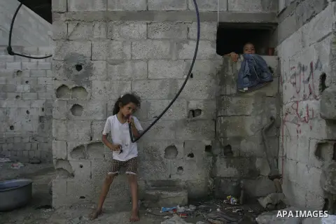 A Palestinian girl drinks water from hosepipe in front of her house in Rafah refugee camp in the southern of Gaza Strip, on September 08. 2012. Photo by Eyad Al Baba