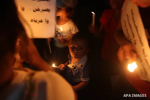 Palestinian children light candles during a rally in solidarity with prisoners in Israeli jails, in front of the Red Cross' offices in Gaza city, September 08, 2012. Photo by Majdi Fathi