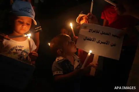 Palestinian children light candles during a rally in solidarity with prisoners in Israeli jails, in front of the Red Cross' offices in Gaza city, September 08, 2012. Photo by Majdi Fathi