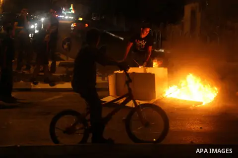 A Palestinian youth burns tyres during a protest against the high cost of living at Al-Amari refugee camp in the West Bank city of Ramallah on September 8, 2012. Dozens of Palestinians burned tyres and blocked the road i...