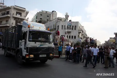 Palestinian truck drivers block a road during a protest against the high cost of living in the West Bank city of Ramallah, Sunday, Sep. 09, 2012. Photo by Issam Rimawi