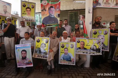 Palestinians hold a placard depicting jailed relatives during a protest in Gaza City calling for the release of Palestinian prisoners from Israeli jails September 10, 2012. Photo by Ashraf Amra