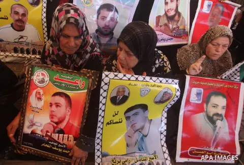 Palestinians hold a placard depicting jailed relatives during a protest in Gaza City calling for the release of Palestinian prisoners from Israeli jails September 10, 2012. Photo by Ashraf Amra