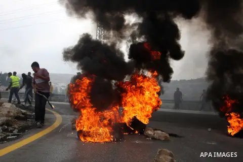 Palestinian youths close streets in Ramallah by burning tires during a protest against the high cost of living on September 10, 2012. Cities across the West Bank ground to a halt as transport unions called a mass general...