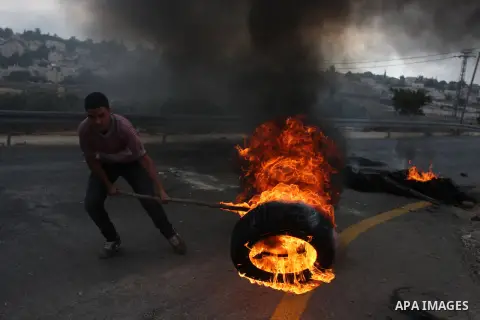 Palestinian youths close streets in Ramallah by burning tires during a protest against the high cost of living on September 10, 2012. Cities across the West Bank ground to a halt as transport unions called a mass general...