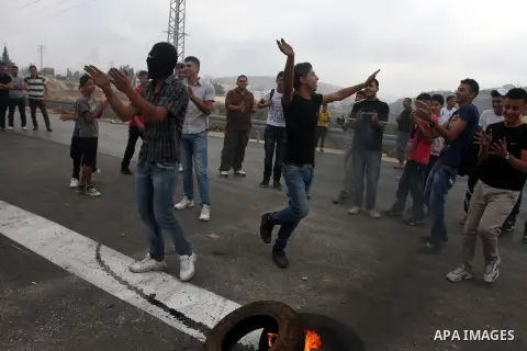 Palestinian youths close streets in Ramallah by burning tires during a protest against the high cost of living on September 10, 2012. Cities across the West Bank ground to a halt as transport unions called a mass general...