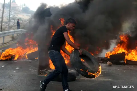 Palestinian youths close streets in Ramallah by burning tires during a protest against the high cost of living on September 10, 2012. Cities across the West Bank ground to a halt as transport unions called a mass general...