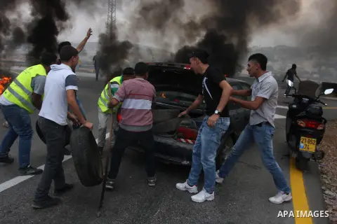 Palestinian youths close streets in Ramallah by burning tires during a protest against the high cost of living on September 10, 2012. Cities across the West Bank ground to a halt as transport unions called a mass general...