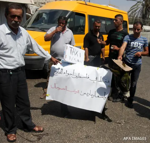 Palestinians ride a donkey and shout slogans during a protest against the high cost of living on September 10, 2012 in the West Bank city of Ramallah. Cities across the West Bank ground to a halt as transport unions call...