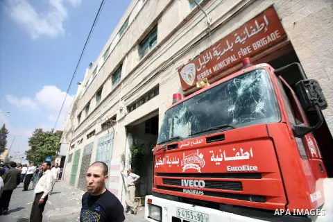 Palestinians stand in front of the municipality in the southern city of Hebron on September 10, 2012 during a demonstration against the high cost of living. Cities across the West Bank ground to a halt as transport union...