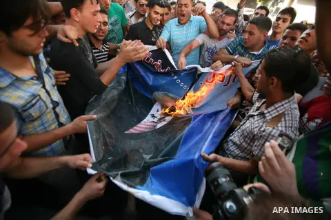 Palestinian protesters burn a portrait of Prime Minister Salam Fayyad during a demonstration against the high cost of living in the southern West Bank city of Hebron on September 10, 2012. The Palestinian Authority is un...