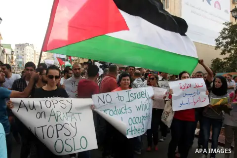 Palestinians wave their national flag during a protest against the Paris Protocol and the Oslo Agreement, both key accords which govern economic ties between Palestinians and Israelis, in the West Bank city of Ramallah o...