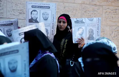 Palestinian women hold a placard depicting jailed relatives during a protest in Gaza City calling for the release of Palestinian prisoners from Israeli jails September 12 2012. Photo by Ashraf Amra