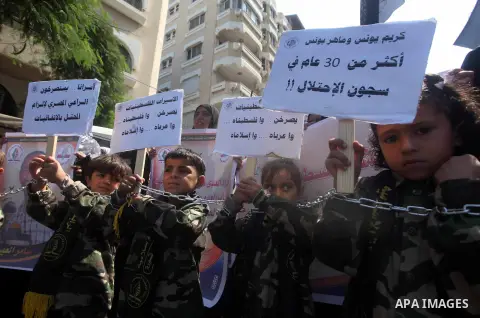 Palestinian children hold a placard depicting jailed relatives during a protest in Gaza City calling for the release of Palestinian prisoners from Israeli jails September 12 2012. Photo by Ashraf Amra