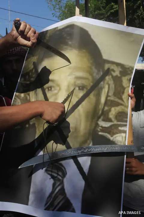 Palestinians point swords on the portrait of the director of a movie that is allegedly offensive to Muslim Prophet Mohammad, during a protest in front of the United Nations headquarters in Gaza city, Sept 12, 2012. Photo...