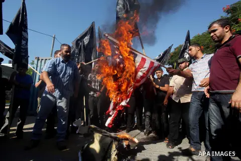 Palestinians burn the U.S. flag during a protest in front of the United Nations headquarters in Gaza city against the showing of a movie that is allegedly offensive to Muslim Prophet Mohammad, Sept 12, 2012. Photo by Ash...