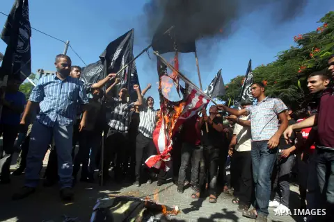Palestinians burn the U.S. flag during a protest in front of the United Nations headquarters in Gaza city against the showing of a movie that is allegedly offensive to Muslim Prophet Mohammad, Sept 12, 2012. Photo by Ash...
