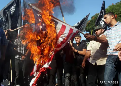 Palestinians burn the U.S. flag during a protest in front of the United Nations headquarters in Gaza city against the showing of a movie that is allegedly offensive to Muslim Prophet Mohammad, Sept 12, 2012. Photo by Ash...