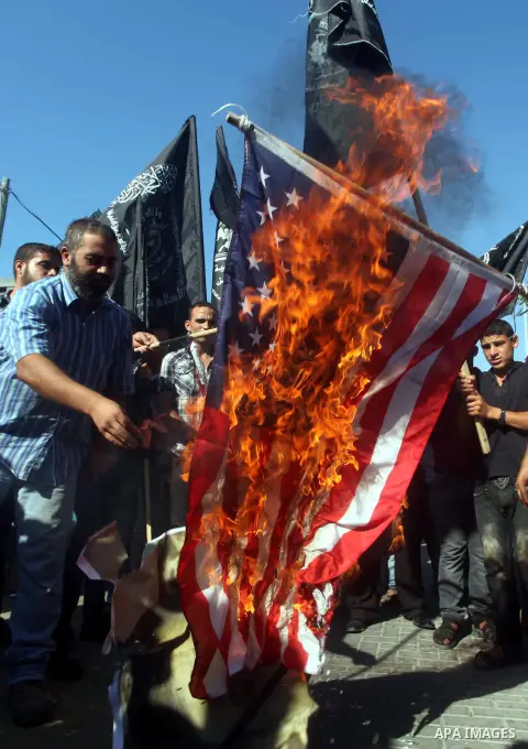 Palestinians burn the U.S. flag during a protest in front of the United Nations headquarters in Gaza city against the showing of a movie that is allegedly offensive to Muslim Prophet Mohammad, Sept 12, 2012. Photo by Ash...