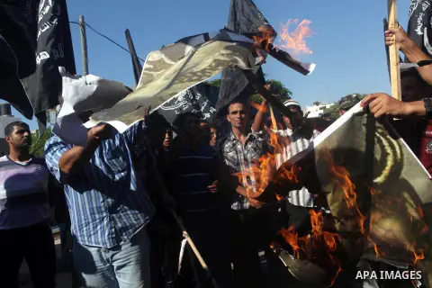 Palestinian burn a portrait of the director of a movie that is allegedly offensive to Muslim Prophet Mohammad, during a protest in front of the United Nations headquarters in Gaza city, Sept 12, 2012. Photo by Ashraf Amr...