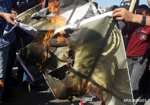 Palestinian burn a portrait of the director of a movie that is allegedly offensive to Muslim Prophet Mohammad, during a protest in front of the United Nations headquarters in Gaza city, Sept 12, 2012. Photo by Ashraf Amr...