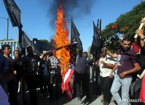 Palestinians burn the U.S. flag during a protest in front of the United Nations headquarters in Gaza city against the showing of a movie that is allegedly offensive to Muslim Prophet Mohammad, Sept 12, 2012. Photo by Ash...