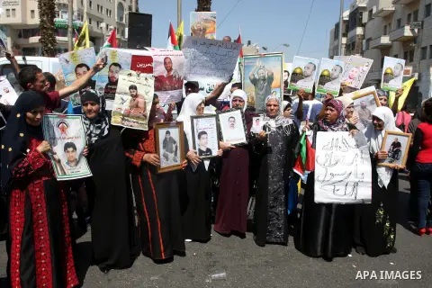 Palestinians hold portraits of their relatives held in Israeli jails during a protest calling for their release, in the West Bank city of Ramallah, Sept. 13, 2012. Photo by Issam Rimawi