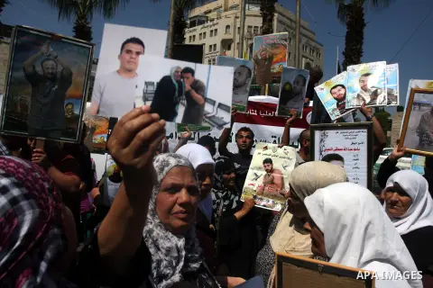 Palestinians hold portraits of their relatives held in Israeli jails during a protest calling for their release, in the West Bank city of Ramallah, Sept. 13, 2012. Photo by Issam Rimawi