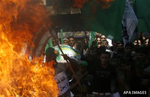 Palestinians burn the U.S. flag during a demonstration against the controversial film 'Innocence of Muslims' in Rafah southern Gaza strip, on September 14, 2012. The controversial low budget film reportedly made by an Is...