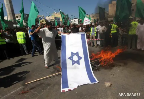 Palestinians burn the Israeli and the U.S. flags during a demonstration against the controversial film 'Innocence of Muslims' in Khan Younis southern Gaza strip, on September 14, 2012. The controversial low budget film r...