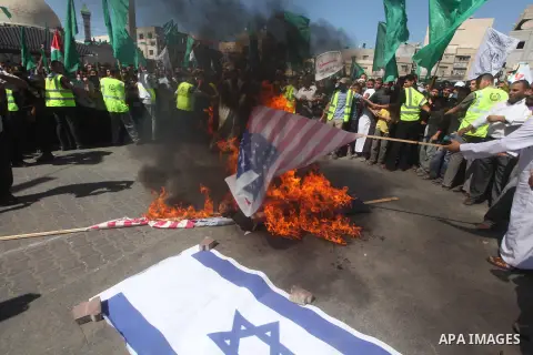 Palestinians burn the Israeli and the U.S. flags during a demonstration against the controversial film 'Innocence of Muslims' in Khan Younis southern Gaza strip, on September 14, 2012. The controversial low budget film r...