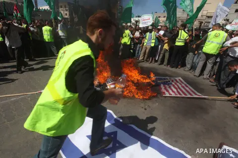 Palestinians burn the Israeli and the U.S. flags during a demonstration against the controversial film 'Innocence of Muslims' in Khan Younis southern Gaza strip, on September 14, 2012. The controversial low budget film r...