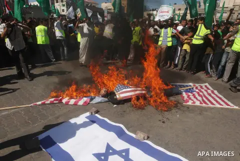 Palestinians burn the Israeli and the U.S. flags during a demonstration against the controversial film 'Innocence of Muslims' in Khan Younis southern Gaza strip, on September 14, 2012. The controversial low budget film r...
