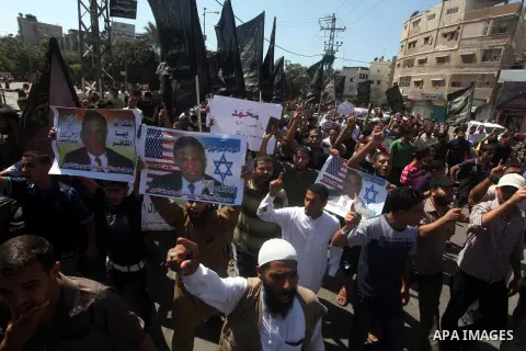 Palestinians hold placards as they shout anti-U.S. slogans during a demonstration against the controversial film 'Innocence of Muslims' in Khan Younis southern Gaza strip, on September 14, 2012. The controversial low bud...