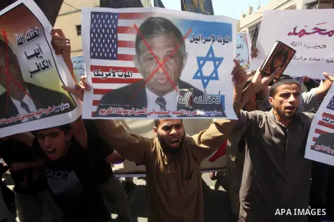 Palestinians hold placards as they shout anti-U.S. slogans during a demonstration against the controversial film 'Innocence of Muslims' in Khan Younis southern Gaza strip, on September 14, 2012. The controversial low bud...