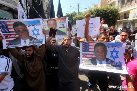 Palestinians hold placards as they shout anti-U.S. slogans during a demonstration against the controversial film 'Innocence of Muslims' in Khan Younis southern Gaza strip, on September 14, 2012. The controversial low bud...