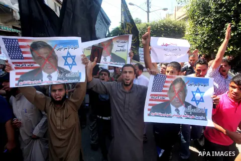 Palestinians hold placards as they shout anti-U.S. slogans during a demonstration against the controversial film 'Innocence of Muslims' in Khan Younis southern Gaza strip, on September 14, 2012. The controversial low bud...