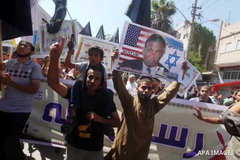 Palestinians hold placards as they shout anti-U.S. slogans during a demonstration against the controversial film 'Innocence of Muslims' in Khan Younis southern Gaza strip, on September 14, 2012. The controversial low bud...